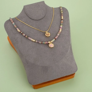 Gold plated garnet pomegranate pendant necklaces set on professional velvet jewelry display