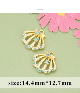 Detailed view of 14.4mm gold shell pendants with inlaid blue and white zircons