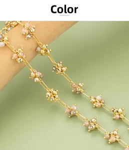 Detailed close-up of handmade gold-plated fireworks chain with crystal beads on wood