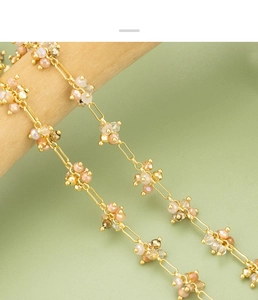 Close-up of gold-plated chain featuring handmade beads in pink and champagne tones
