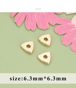 Makroaufnahme von 6,3mm goldener Dreiecksperle mit Textur für DIY-Schmuckherstellung