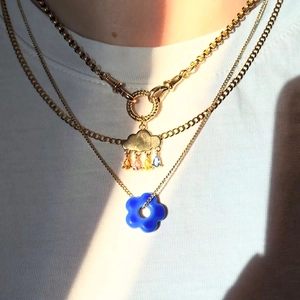 Layered gold necklace with cloud and blue flower pendants featuring colorful zircon stones