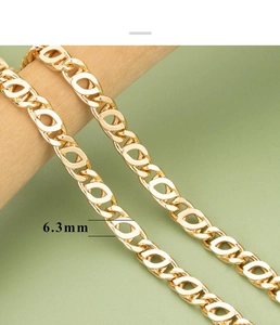 Primer plano de cadena marina dorada de 6,3mm sobre soporte de madera