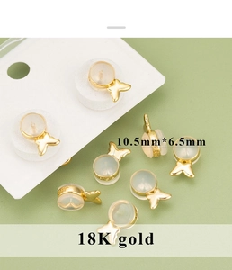 Detailed macro view of 10.5mm 18K gold butterfly earring backs with clear silicone base