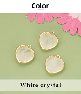 Détail de pendentifs en cristal blanc en forme de cœur avec bordure dorée sur fond vert