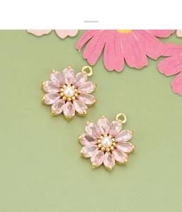 Détail du pendentif fleur avec zircone rose et perle sur un fond vert pastel