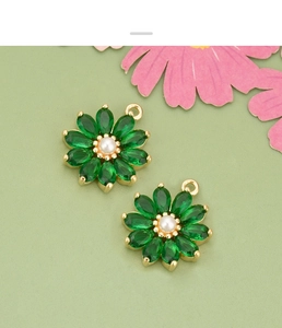 Vue détaillée de breloques fleurs vertes avec perle centrale et métal doré diy