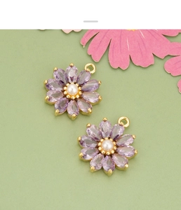 Détail d'un pendentif fleur marguerite en zircon violet avec perle et base dorée