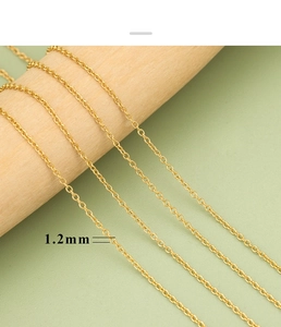 Makro-Detail einer 1,2 mm 18K vergoldeten Edelstahlkette auf Holzhintergrund