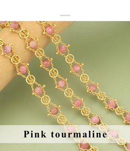 Detailopname van roze toermalijn kralen aan een vintage vergulde koperen ketting