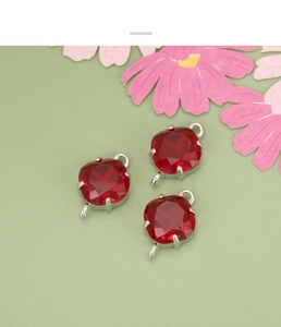 Close-up of three dark red square glass charms with silver connectors for DIY jewelry