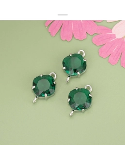 Detailed macro of emerald green cushion cut glass charms with double silver connectors