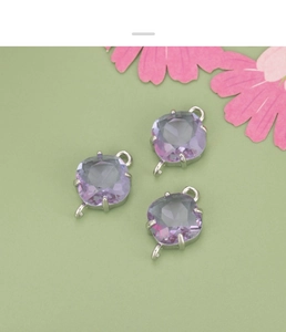 Macro detail of three purple cushion-cut glass diamond charms with silver plated connectors