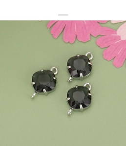 Detail of rhombus glass crystal connectors in dark smoky grey with silver metal claw settings