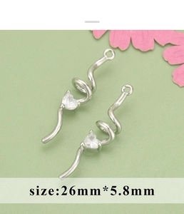 Macro detail of S-shaped silver-plated earring pendants with heart zircon stones for DIY