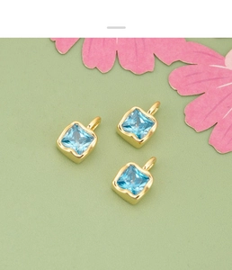 Detail view of square sky blue zircon pendants with golden edging for DIY jewelry making