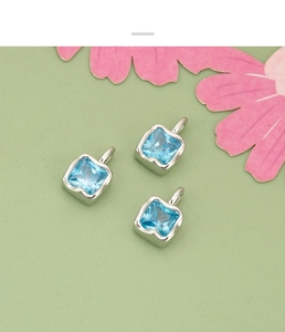 Detailed view of three square blue zircon pendants with silver metal frames for DIY jewelry