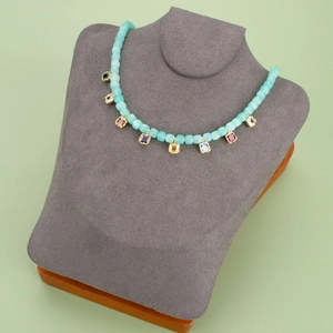 Beaded necklace with eight colorful square zircon pendants on a grey jewelry bust display