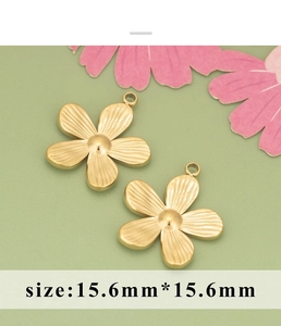 Detailed view of two 15.6mm golden daisy flower pendants with textured petals on a green base