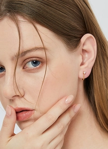 Close-up of elegant gold U-shaped stud earrings with sparkling cubic zirconia on model