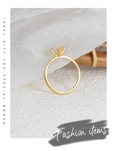 Side view detail of a gold crown ring with a four-claw set round cubic zirconia