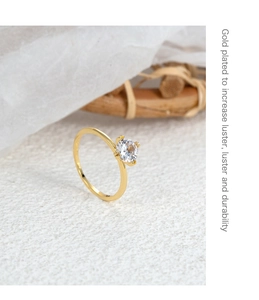 Macro detail of gold plated four-prong crown ring with round cubic zirconia stone