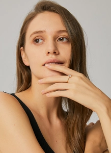 Close-up of a classic gold plated crown ring with a round zircon stone on model hand