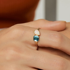 Anillo dorado con ópalo blanco en forma de pera y gema azul de corte cuadrado fino