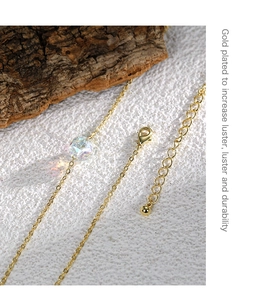 Détail d'une chaîne plaquée or avec perle en cristal facettée et fermoir mousqueton