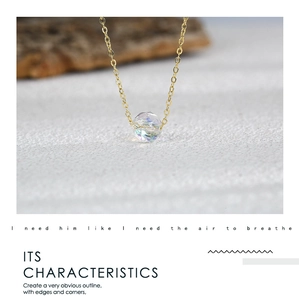 Vue macro d'un collier plaqué or avec un pendentif en cristal facetté aux reflets irisés