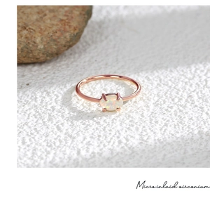 Detailansicht des rotgoldenen Rings mit ovalem Opal und mikro-eingesetzten Zirkonias
