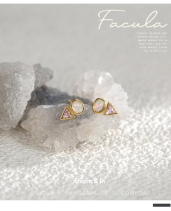 Detail of geometric earrings with pink triangle zircon and opal stones in gold setting