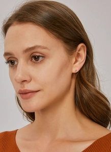 Gros plan de boucles d'oreilles gouttes dorées avec zircon violet sur un mannequin