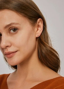 Détail des boucles d'oreilles puces avec zircon violet en forme de goutte