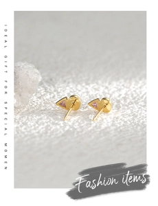 Macro view of geometric gold earrings with triangle pink zircon and opal inlay details