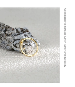 Detalle de un anillo de circón cuadrado chapado en oro sobre una piedra natural gris
