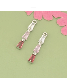 Close-up of geometric 18K gold plated pendants with gradient pink and white zircon stones