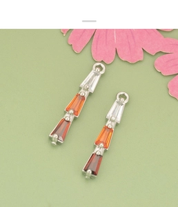 Detailed view of copper-plated gold geometric pendants with tricolor gradient zircon stones