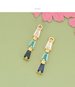 Close-up of 18K gold plated geometric pendants with gradient blue cubic zirconia stones