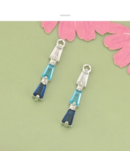 Detailed view of silver-plated charms with blue gradient trapezoid-cut cubic zirconia