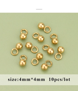 Macro shot of 4mm golden stainless steel spacer beads with loops for DIY jewelry making
