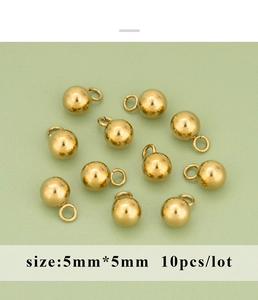 Close-up of 5mm golden stainless steel crimp beads with jump rings for jewelry making
