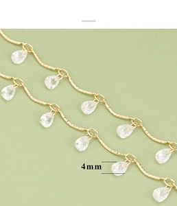 Detalle macro de dijes de circón de 4mm en cadena de joyería chapada en oro 18k