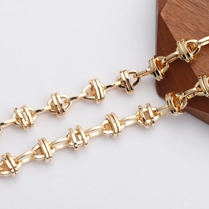 Dettaglio macro di catena a croce vintage placcata oro 18K con maglie lucide