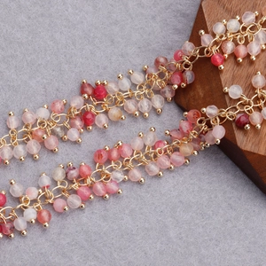Macro view of 18K gold plated beaded chain with pink and red multifaceted crystals