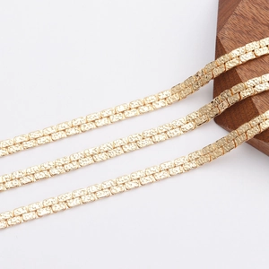 Detail of 18K gold-plated flat nugget chain showing textured links and metallic finish