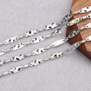 Macro shot of silver-colored hammered oval metal pieces and spiral wire connectors