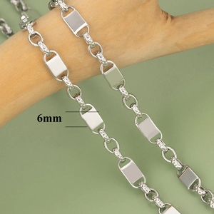 Detailaufnahme der 6mm breiten silbernen Kettenglieder mit Gravur auf Naturholz
