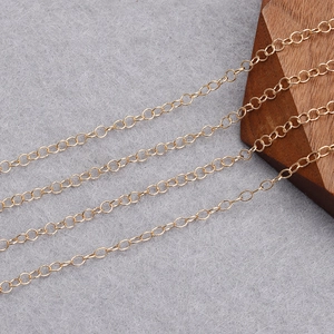 Macro shot of gold plated cross chain DIY material on a textured grey surface