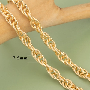 Close-up of 7.5mm gold plated keel chain with embossed texture on decorative wood
